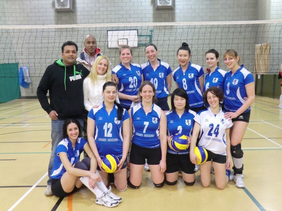 Lionhearts women's squad and coaches in blue kit, posed on court after a match